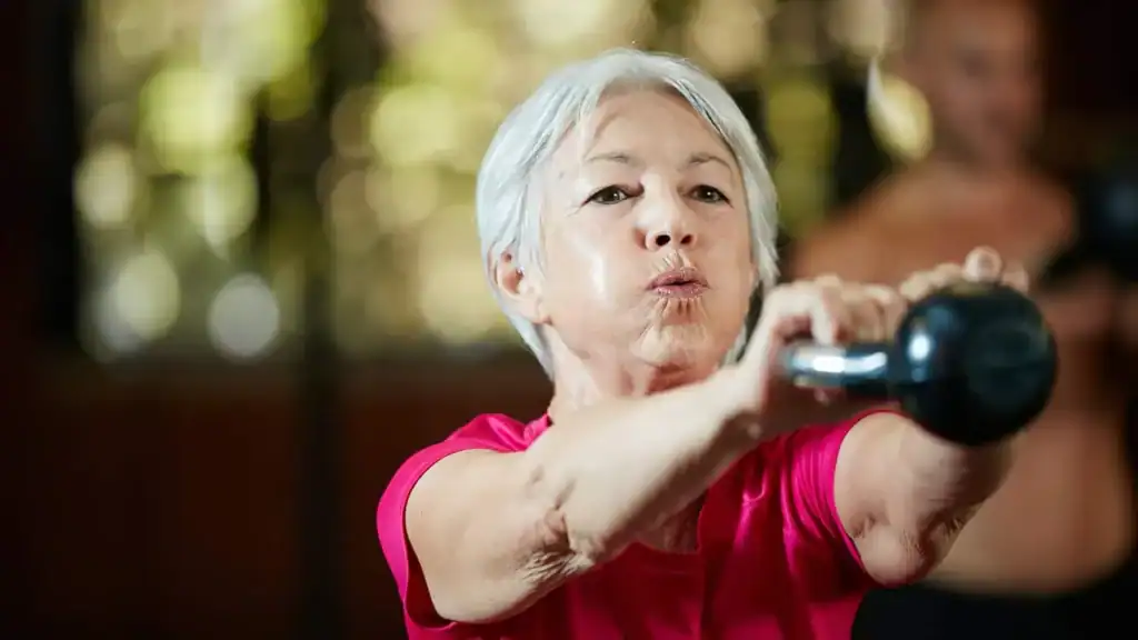 Toning Arms After 60: Empowering Womens Fitness Through Effective Weight Training 1 Older woman doing weight training Bridport to help her strength and longevity