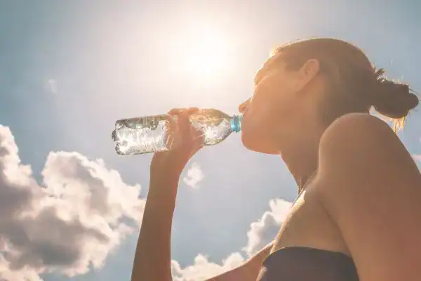 Hydration: The Secret Ingredient for a Toned Stomach and Enhanced Fitness 3 Image of woman drinking water to hydrate Bridport after run.