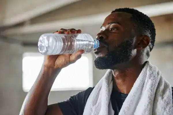 Hydration: The Secret Ingredient for a Toned Stomach and Enhanced Fitness 1 Image of man drinking water to improve hydration Bridport after work out.